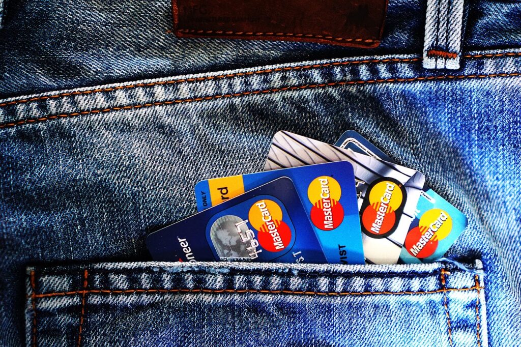 Une personne qui porte un jeans dans le quelle y il a 4 carte bancaire 